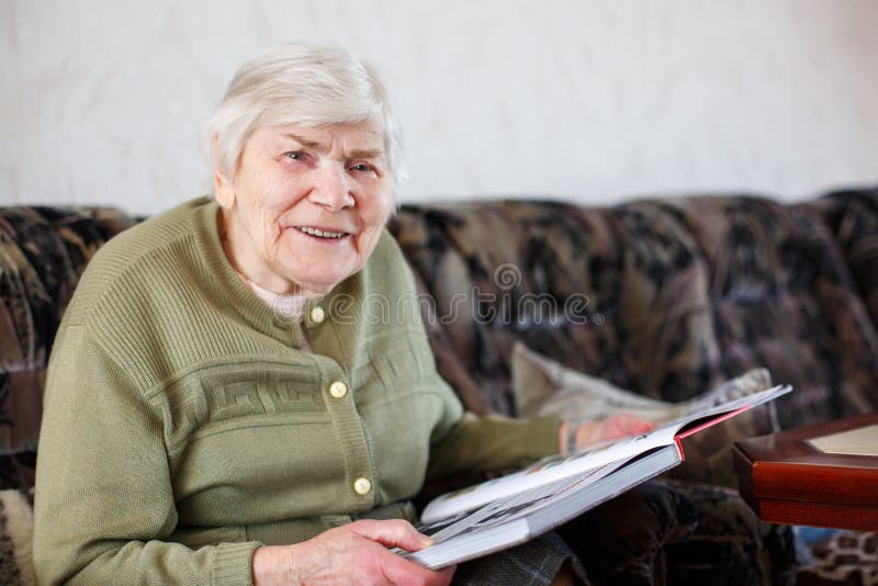 Vieja mujer mayor hermosa de 85 años de libro de lectura, dentro imagen de archivo libre de regalías Vieja mujer mayor hermosa de 85 años de libro de lectura, dentro imagen de archivo libre de regalías