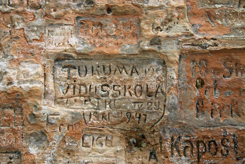 Viejas inscripciones en la cueva de Gautmanis situada en el río de Gauja en el parque nacional de Sigulda, Letonia imágenes de archivo libres de regalías Viejas inscripciones en la cueva de Gautmanis situada en el río de Gauja en el parque nacional de Sigulda, Letonia imágenes de archivo libres de regalías