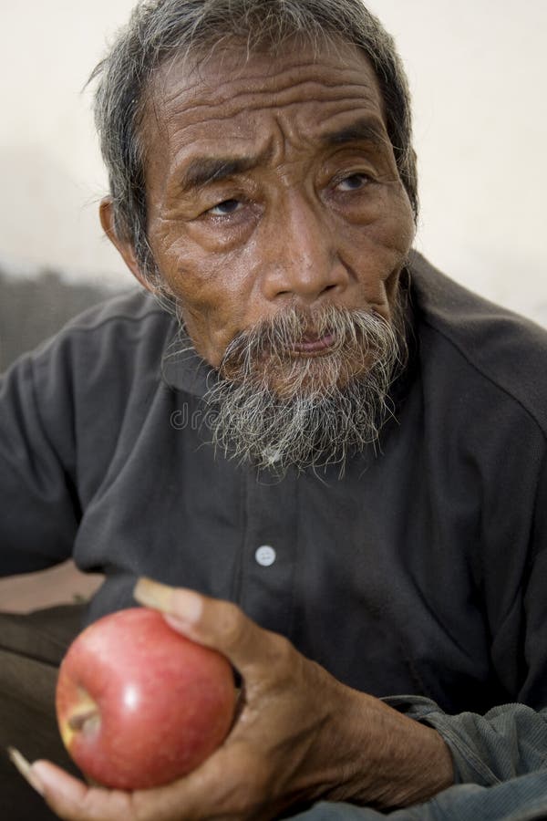 Viejo hombre asiático con la manzana imágenes de archivo libres de regalías Viejo hombre asiático con la manzana imágenes de archivo libres de regalías