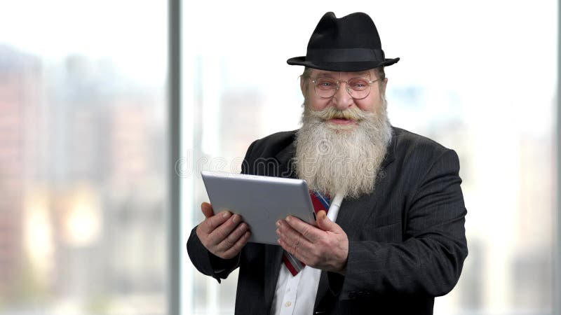 Viejo hombre de negocios riéndose mirando la tableta digital. almacen de metraje de vídeo