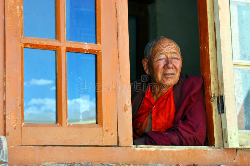 August 2012, Ladakh, also called Little Tibet (India) - An old monk is looking at the window. August 2012, Ladakh, also called Little Tibet (India) - An old monk is looking at the window