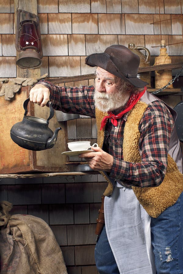 Viejo vaquero con la taza de té de la caldera y de China imagenes de archivo Viejo vaquero con la taza de té de la caldera y de China imagenes de archivo