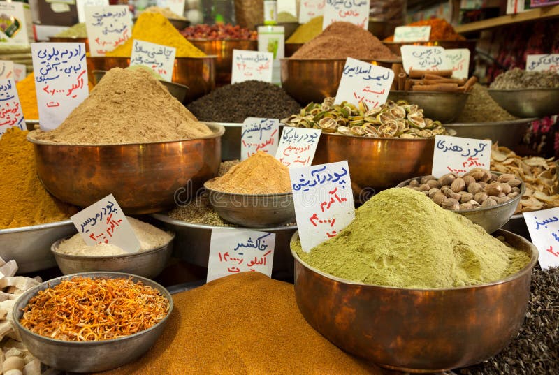 Varieties of colorful aromatic spice powders and dried herbs in traditional copper bowls in an old bazaar of Iran. Varieties of colorful aromatic spice powders and dried herbs in traditional copper bowls in an old bazaar of Iran.