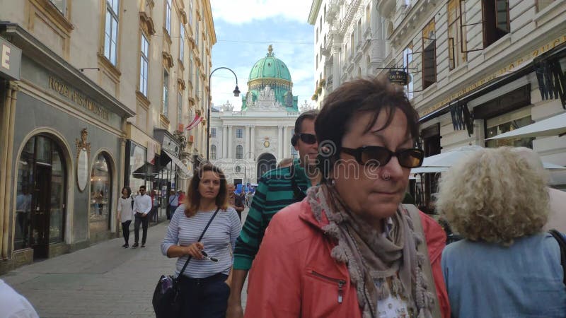Viena, Áustria - 15 de setembro de 2018: Tempos na rua Kohlmarkt com vista à presença de Michaelerplatz e de Hofburg Wien