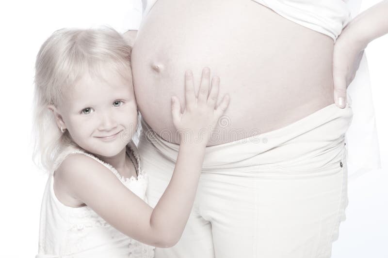Vientre que escucha de la niña de su madre embarazada fotos de archivo Vientre que escucha de la niña de su madre embarazada fotos de archivo