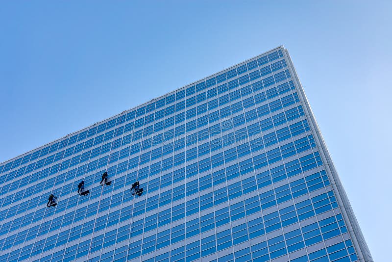 Vier Fensterputzer auf der Seite eines Wolkenkratzers lizenzfreie stockfotografie Vier Fensterputzer auf der Seite eines Wolkenkratzers lizenzfreie stockfotografie