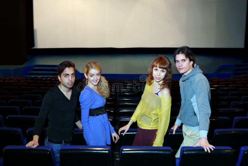 Vier jonge vriendentribune in de zaal van het bioskooptheater stock afbeeldingen Vier jonge vriendentribune in de zaal van het bioskooptheater stock afbeeldingen