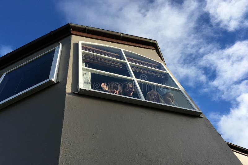 Vier Kinder, die von einem Fenster zum Abschied winken lizenzfreie stockfotografie Vier Kinder, die von einem Fenster zum Abschied winken lizenzfreie stockfotografie