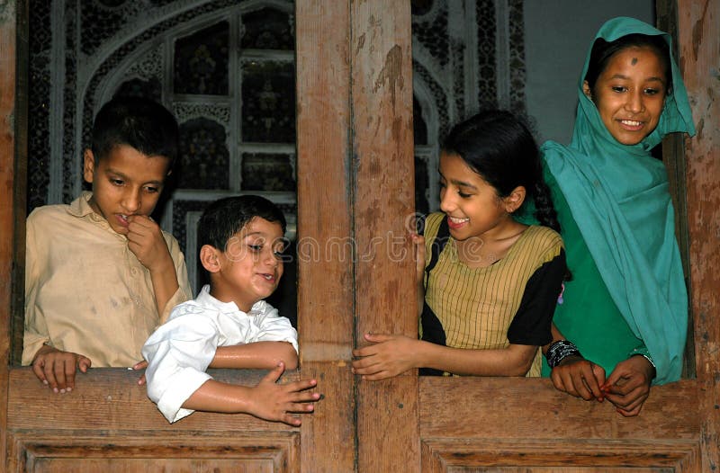 Vier Kinder schauen von einem Fenster in einem Heim in Peshawar, Pakistan