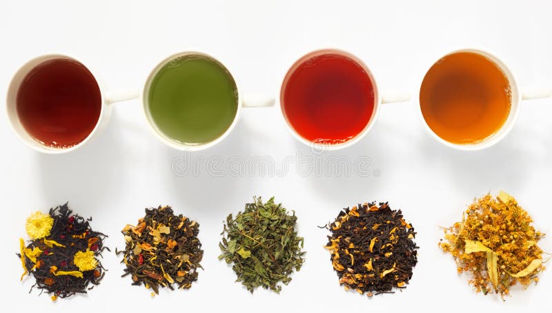 Vier Tassen Tee auf weißem Tisch mit großen Sortiment von Kräuterblumenbeere lizenzfreies stockfoto