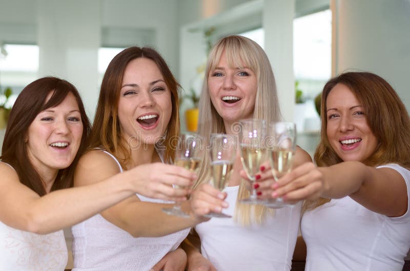 Four merry women partying and toasting with flutes of champagne laughing as they celebrate a special occasion, holiday or success, close up upper bodies. Four merry women partying and toasting with flutes of champagne laughing as they celebrate a special occasion, holiday or success, close up upper bodies