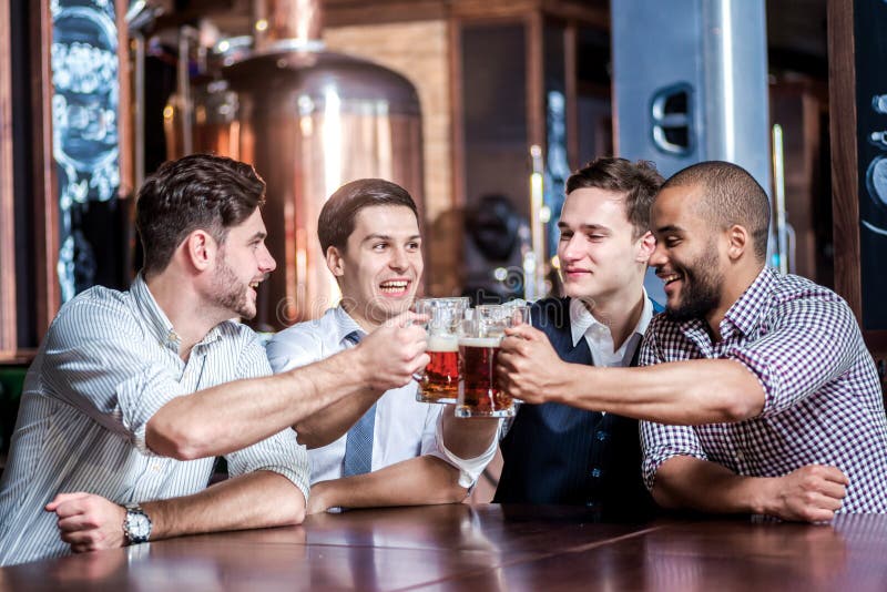 Vier zakenlieden drinken bier en verheugen zich samen bij de bar Suc stock afbeeldingen Vier zakenlieden drinken bier en verheugen zich samen bij de bar Suc stock afbeeldingen