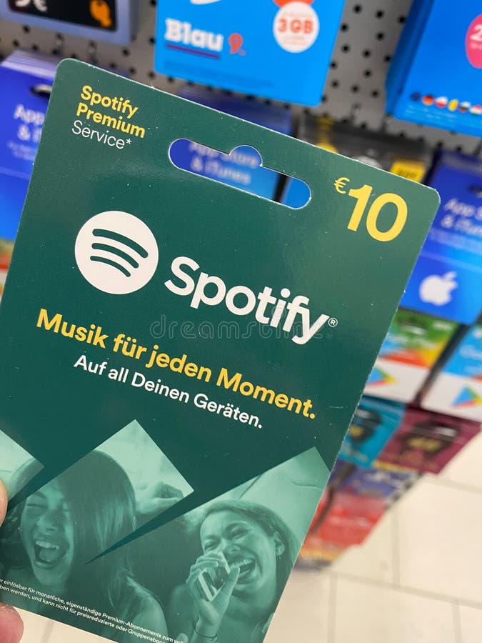 View on spotify gift voucher card hold by hand in german supermarket focus on card