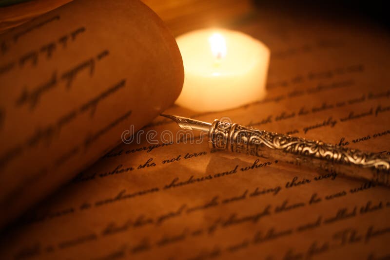 View on isolated text on old yellow paper with ink pen and candle light focus on pen tip, document is self made