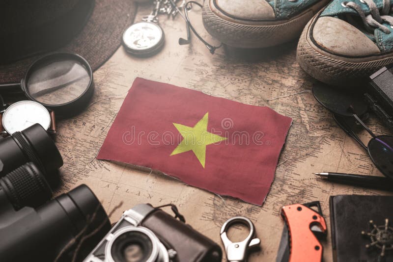 Vietnam Flag Between Traveler`s Accessories on Old Vintage Map. Tourist Destination Concept. Vietnam Flag Between Traveler`s Accessories on Old Vintage Map. Tourist Destination Concept.