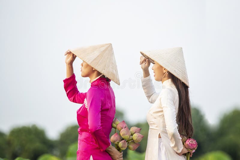 Vietnamese female group on a wooden boat Asian. two women stand on a wooden boat to collect lotus flowers. Three beautiful women stock photo Vietnamese female group on a wooden boat Asian. two women stand on a wooden boat to collect lotus flowers. Three beautiful women stock photo