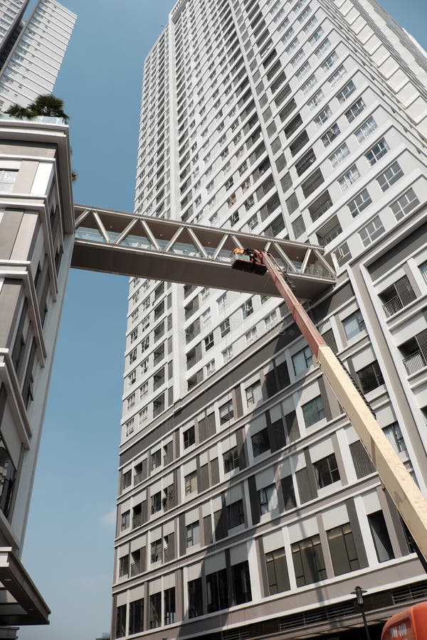 Vietnamese technician in crane truck of maintenance services to repair sky bridge of apartment building royalty free stock photos Vietnamese technician in crane truck of maintenance services to repair sky bridge of apartment building royalty free stock photos