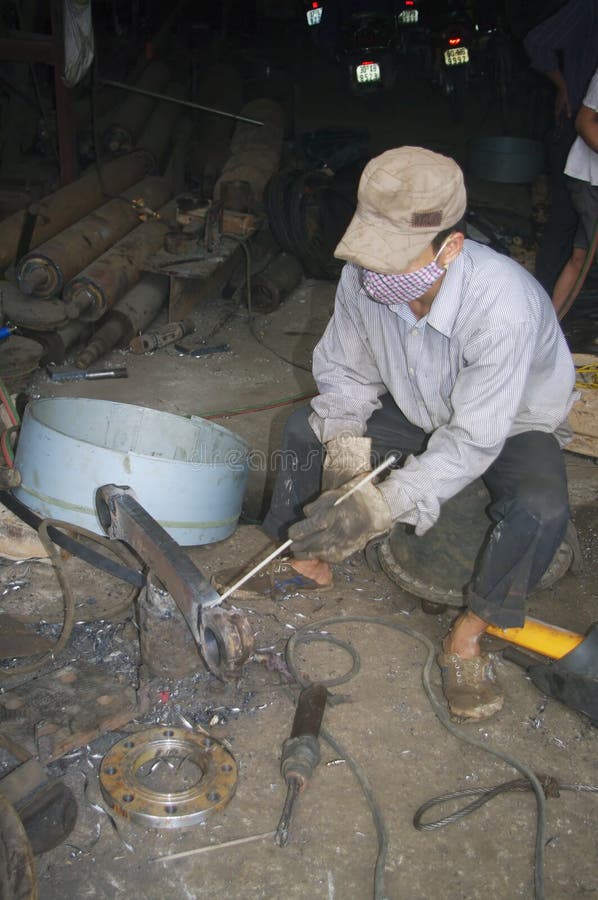 Vietnamese Welder on the Sidewalk Editorial Photography Image of