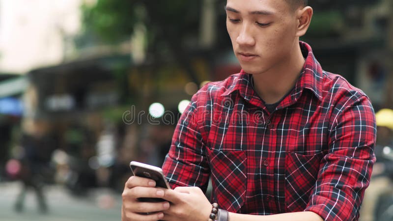 Junger vietnamesischer Mann mit Handy