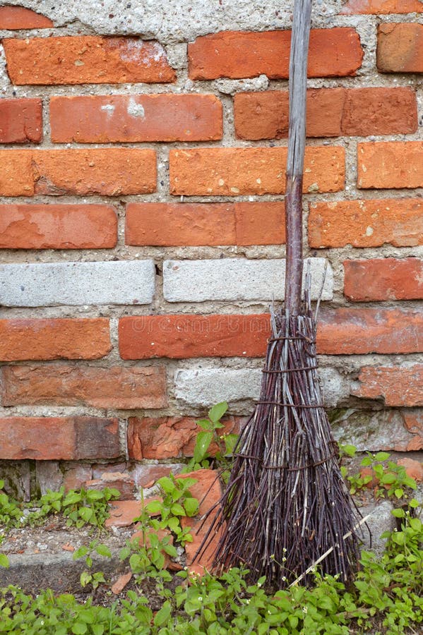 Old broom on old red brick wall background. Old broom on old red brick wall background