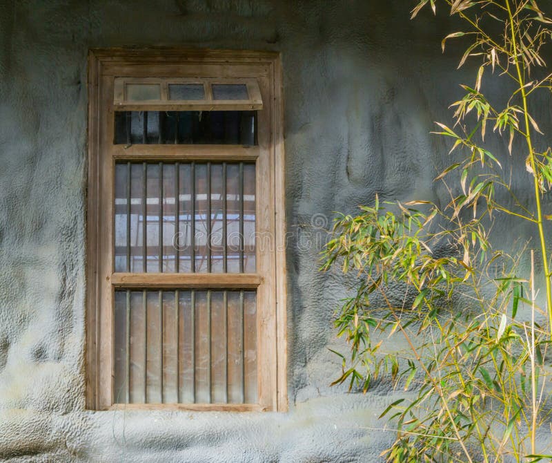 Vieux cadre sale de fenêtre avec des barres de prison dans un mur en pierre photographie stock libre de droits Vieux cadre sale de fenêtre avec des barres de prison dans un mur en pierre photographie stock libre de droits
