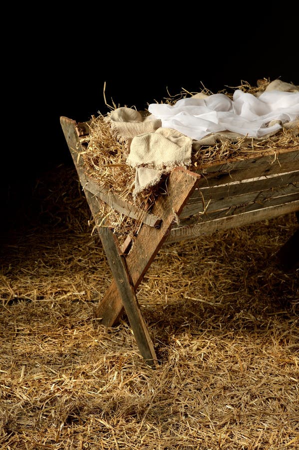 Old manger with swaddling clothes over dark background. Old manger with swaddling clothes over dark background