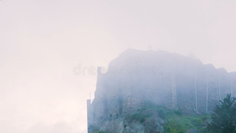 Vieux monastère orthodoxe sur la crête de montagne Bâtiment en pierre brumeux se tenant sur la colline