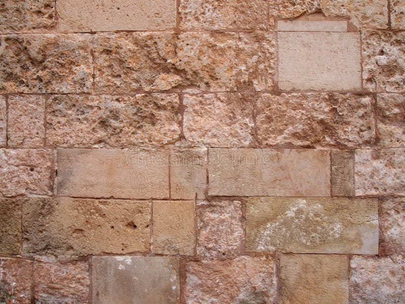 Vieux mur en pierre brun rugueux construit de grands blocs usés avec les pierres endommagées réparées images libres de droits Vieux mur en pierre brun rugueux construit de grands blocs usés avec les pierres endommagées réparées images libres de droits
