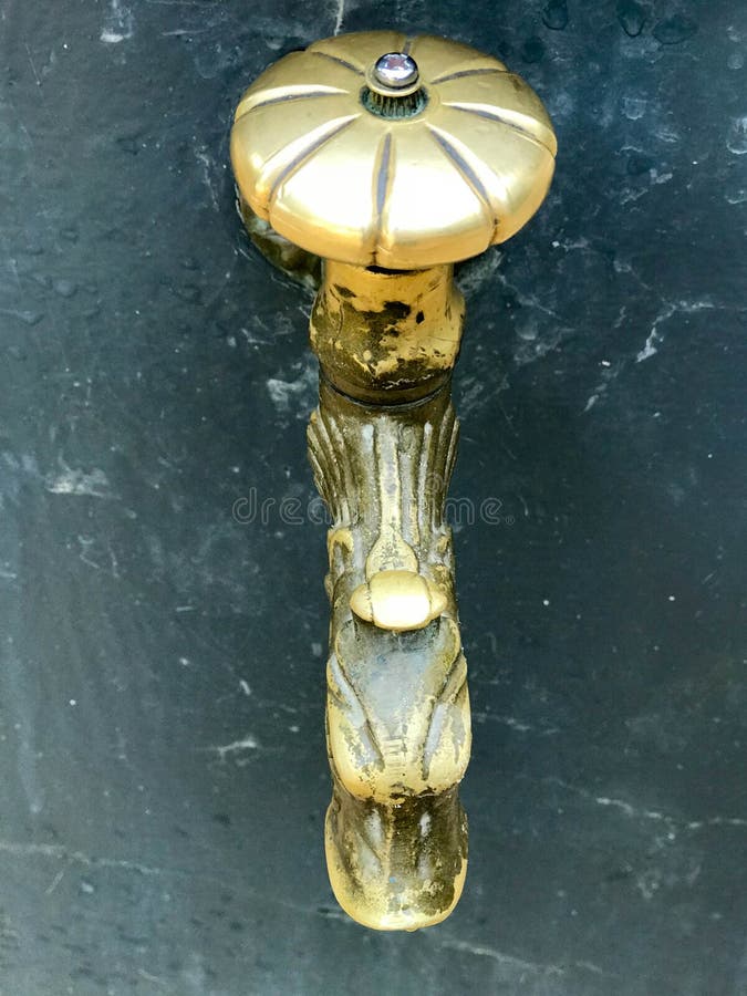 Vieux robinet d'antiquité de fonte forgé par vintage jaune, robinet, garnitures en laiton, cuivre pour les pieds potables et de l image libre de droits Vieux robinet d'antiquité de fonte forgé par vintage jaune, robinet, garnitures en laiton, cuivre pour les pieds potables et de l image libre de droits