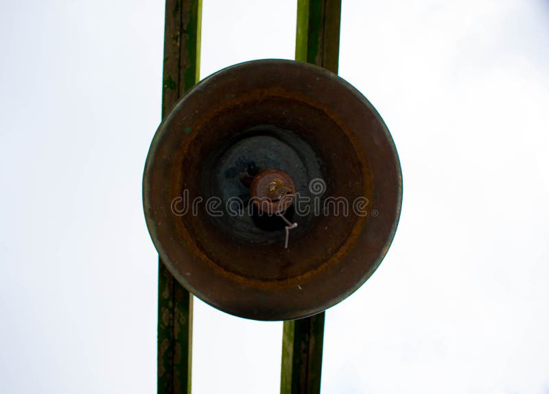 Vieux Rusty Bronze Bell Hanged sur la planche deux en bois moussue images libres de droits Vieux Rusty Bronze Bell Hanged sur la planche deux en bois moussue images libres de droits