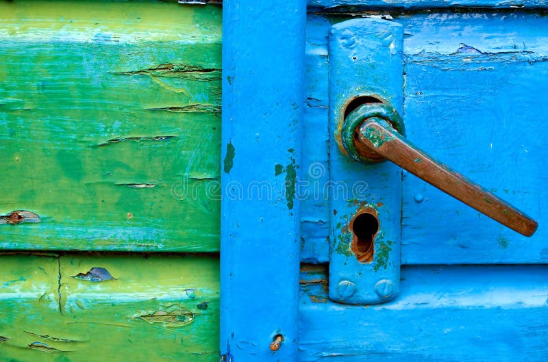 Old door handles with blue and green painted door detail. Old door handles with blue and green painted door detail