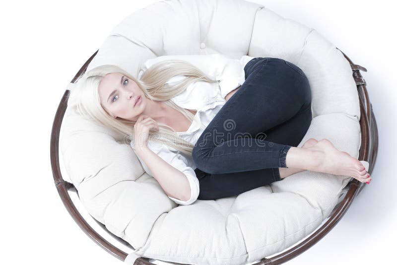 View from above . Close-up of a beautiful sad young woman lying in a large comfortable chair