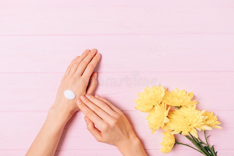 View from above woman s hands applying nourishing cream