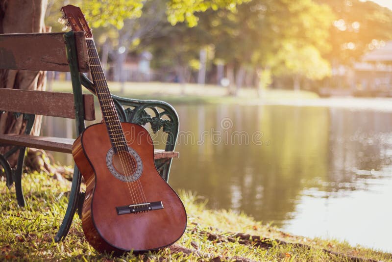View of Acoustic Guitar at Lake. Background the Nature of the Lake