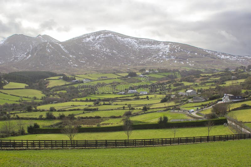 A view across a valley to one of the splendid snow dusted peaks of the Mourne Mountains in County Down Northern Ireland