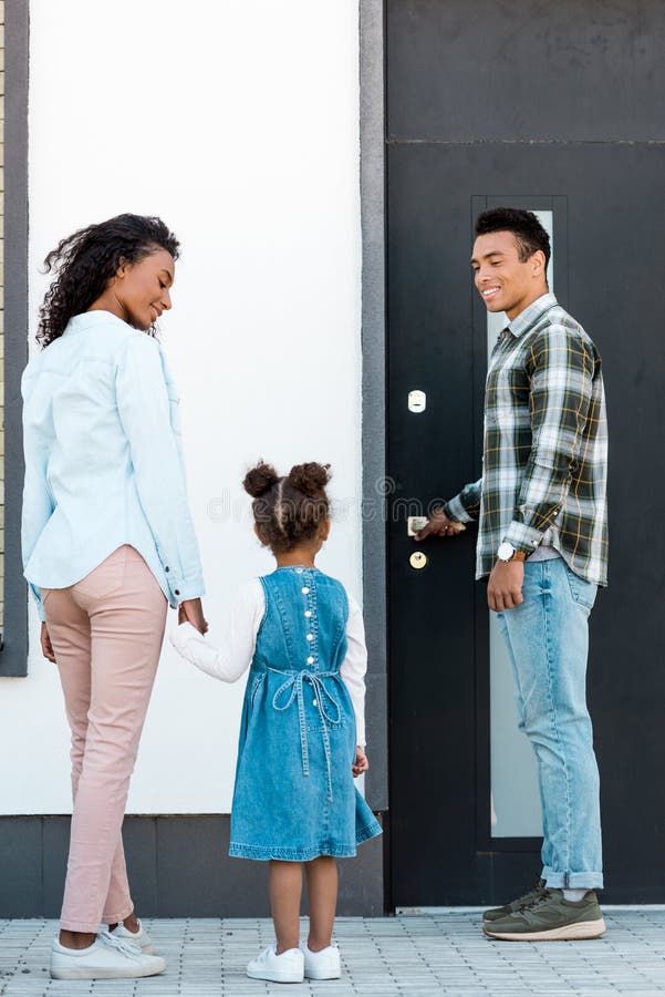 View of african american father opening door while mother and kid walking to man