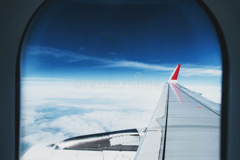 View through aircraft window. beautiful aerial view of blue sky and white clouds at night while traveling stock image View through aircraft window. beautiful aerial view of blue sky and white clouds at night while traveling stock image