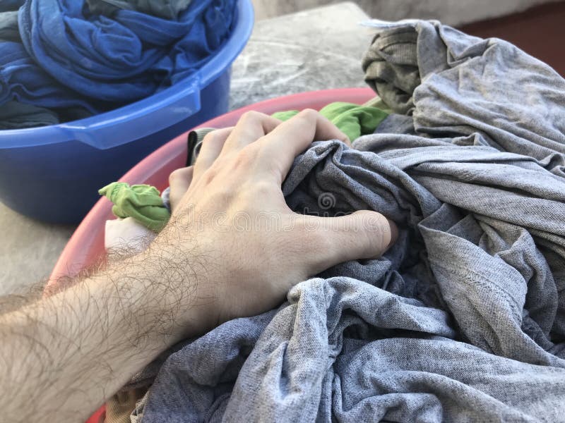 Basket Full of Clean Laundry with a Hand Picking Some Clothes Stock