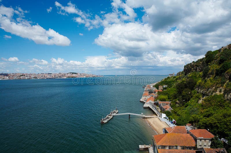 A view at the bay and an old coastal town on a sunny day, Lisbon, Portugal