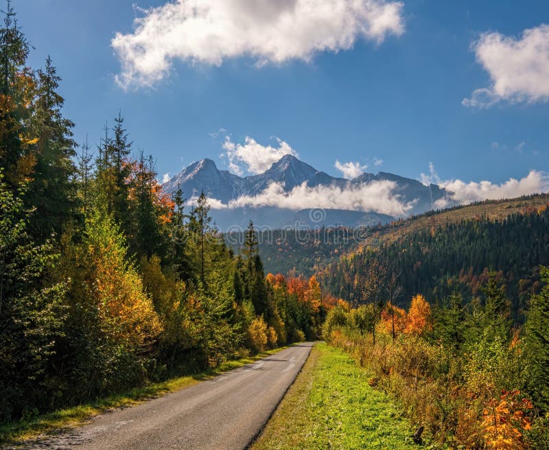 Pohľad na krásnu jesennú krajinu s farebnými stromami a skalnatými štítmi v pozadí. Vysoké Tatry Slovensko.