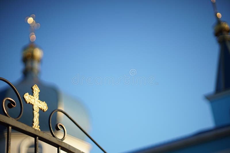 View of the blurred Orthodox Church through a fence with a golden cross stock photography View of the blurred Orthodox Church through a fence with a golden cross stock photography