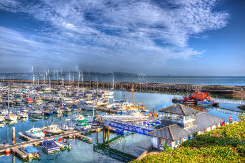 View of Brixham marina harbour walls Devon England UK with calm blue sea and sky in HDR