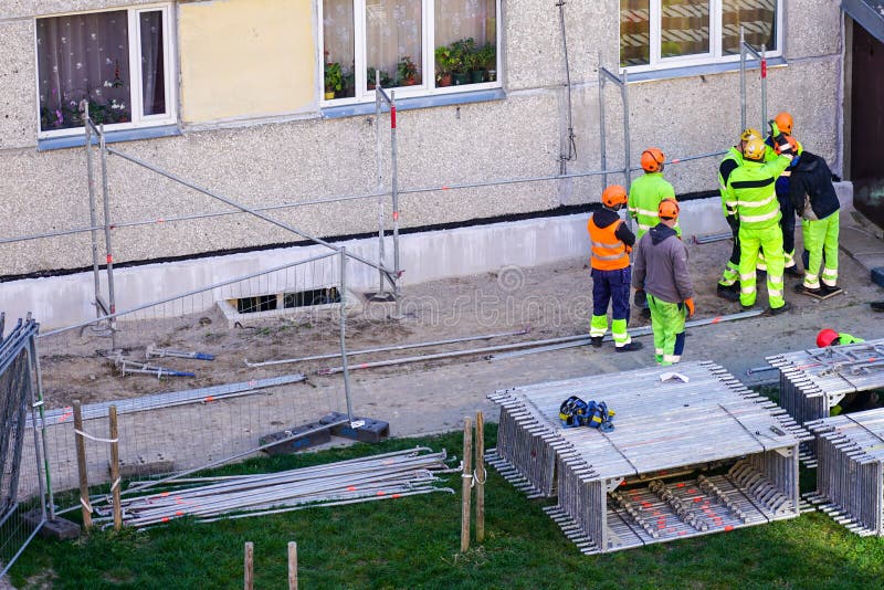 View of builders discussing plans before scaffolding assembly stock photo