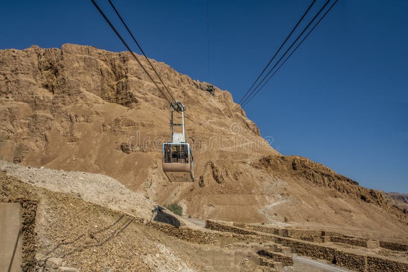 View of the cable car from a low point of view over Mount Massada Israel, the bottom construction, the ruins. stock photo View of the cable car from a low point of view over Mount Massada Israel, the bottom construction, the ruins. stock photo