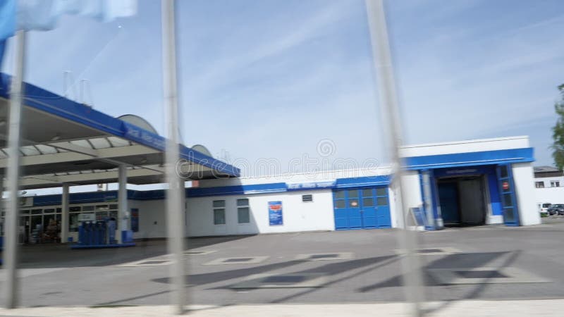 View from car at the large Aral Gas station in blue color with cars refueling