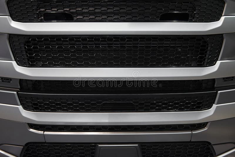 View on car truck cabin radiator cover with grid grille. Car radiator grille background pattern. Gray truck hood cabin front cover