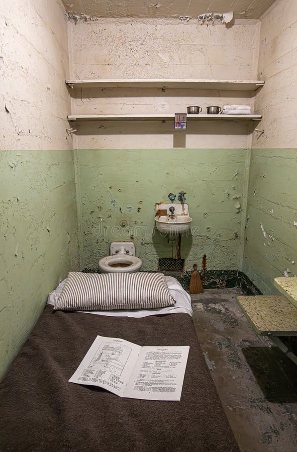 San Francisco, CA, USA - July 12, 2023: Inside historic Alcatraz prison. View in cell with personal hygiene facilities, bed and wall boards to stack stuff. Paper describing layout. San Francisco, CA, USA - July 12, 2023: Inside historic Alcatraz prison. View in cell with personal hygiene facilities, bed and wall boards to stack stuff. Paper describing layout