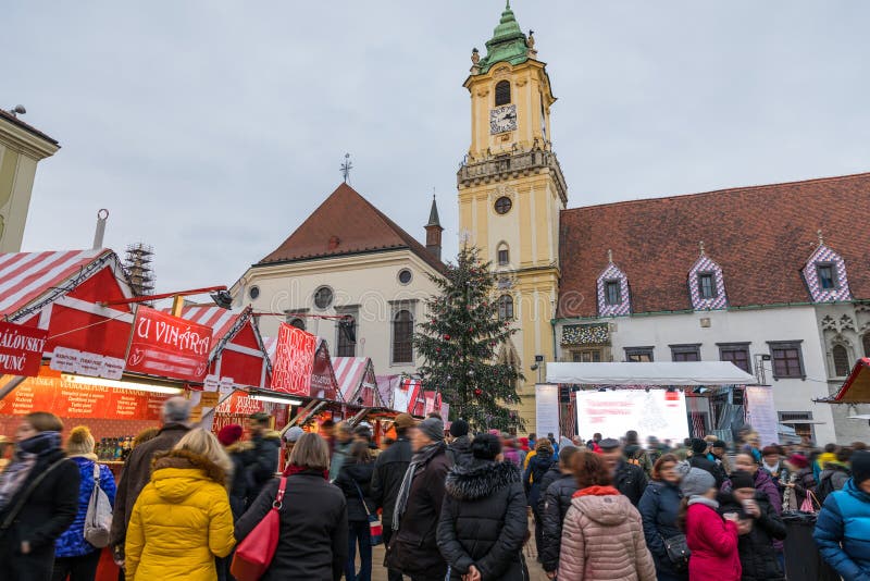 Pohľad na vianočné trhy na Hlavnom námestí v Bratislave. Stará radnica a bratislavské vianočné trhy, rozmazaní ľudia