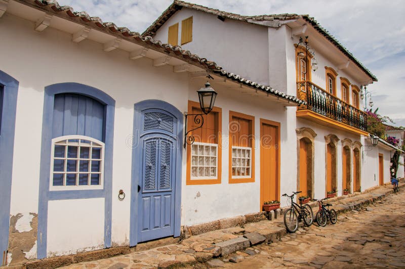 View of cobblestone alley with colorful old houses and bicycles in Paraty.