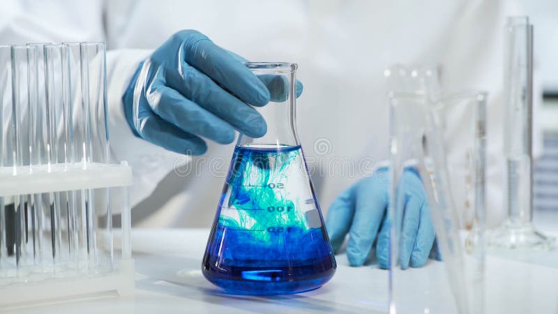 View of conical flask with liquid changing color into blue, biochemistry stock photography